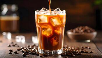 Pouring iced coffee into a glass with ice cubes. Refreshing summer drink with coffee beans scattered on a rustic wooden table. Perfect for cafe or beverage concepts. photo