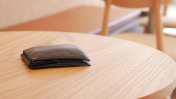 Wallet resting on a wooden table at cafe, lost wallet concept video