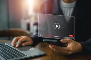 A person interacts with streaming technology on a laptop and smartphone, showcasing a futuristic digital interface. photo