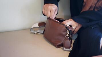 Woman searching through handbag while sitting quietly video