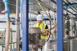 Engineers or factory managers wearing safety helmet inspect the machines in the production line. Utility inspector check machine and test the system to meet the standard. machine. maintenance. photo