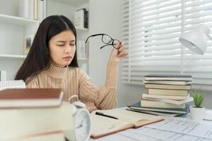 Eye problems, Asian women with tired and irritated eyes, eye rubbing, dry, eye pain after work, migraine, headache, blurred vision, photophobia, eye hurt from Read a book for a long time. photo