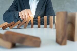 insurance hands protect domino. Businessman hands stop dominoes falling in business crisis. business risk control and planning and strategies to run prevent insurance businesses, photo
