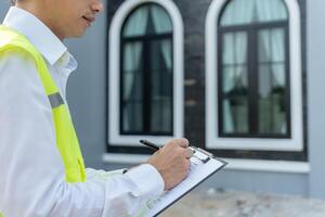 engineer is inspecting construction and quality assurance new house using a checklist. Engineers or architects or contactor work to build the house before handing it over to the homeowner. photo