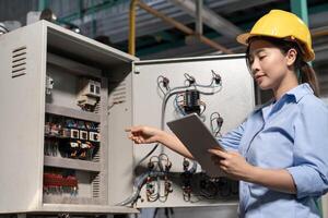 Mechanic or maintenance or electrical engineer checking main electrical control systems industrial plant. Utility fore man daily check power systems in process. Main Distribution Board, Switchboard photo