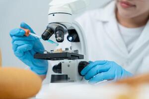 Scientist analyze biochemical samples in advanced scientific laboratory. Medical professional use microscope look microbiological developmental of viral Biotechnology research science lab, photo