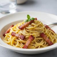 A plate of spaghetti with bacon and basil photo