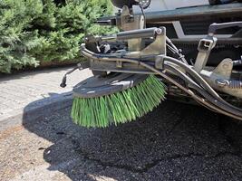 Urban cleanup scene featuring close-up of street sweeper brush in action. A street sweeper or street cleaner photo