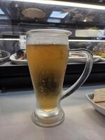 Refreshing cold beer glass in a restaurant setting. Vertical banner. Copy space. International Beer Day photo