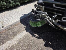 Urban cleanliness concept with street sweeper close-up on pavement. A street sweeper or street cleaner photo