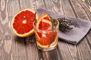A glass of orange juice with a grapefruit slice on top photo