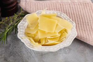 A bowl of cheese and a towel on a table photo