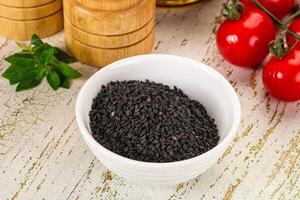 Black sesame seeds in a bowl with tomatoes and spices photo