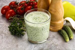 A glass of green smoothie with vegetables and spices photo