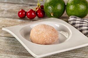 A plate with a ball of dough and cherries photo