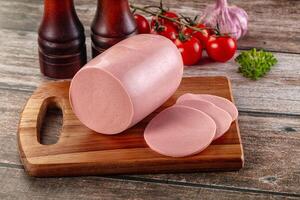 A cutting board with a ham on it and some vegetables photo