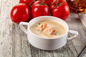 A bowl of soup with some tomatoes and a spoon photo