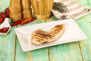 A plate with a grilled chicken and some spices photo