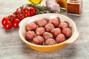 A bowl of meatballs with tomatoes and spices photo