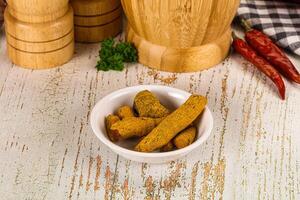 A bowl of food on a table next to a pepper grinder photo