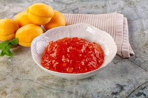 A bowl of sauce and a bowl of fruit photo