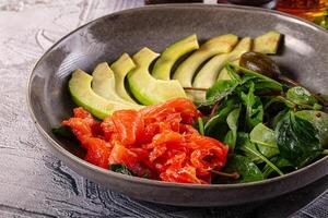 A bowl of food with a salad and some other food photo