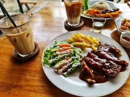 Enjoying Chicken Steak with Fries and Salad at Cafe photo