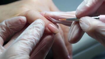 Manicure nail polishing close up view of nail polishing on color back video