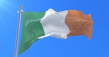 Flag of Ireland waving at wind in slow in blue sky, loop video