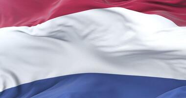 Flag of the Netherlands waving at wind with blue sky in slow, loop video