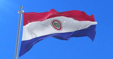 Flag of Paraguay waving at wind with blue sky in slow, loop video
