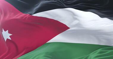 Flag of Jordan waving at wind with blue sky in slow loop video
