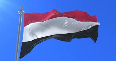 Flag of Yemen waving at wind in slow with blue sky, loop video