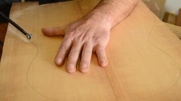 utting wood with hacksaw for a flamenco guitar video