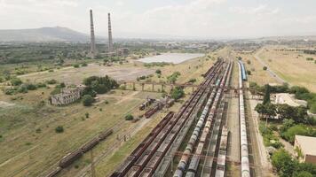 Rustavi, Georgia - 2025- Freight train with Texol tanker wagons moves past large Rustavi industrial complex, with smokestacks, cooling towers, and visible environmental impact in background. video