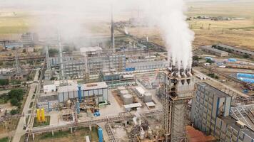 Aerial Rustavi Azot factory complex in Georgia showing production buildings, storage tanks, tall chimneys emitting smoke, and extensive industrial infrastructure video