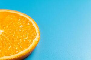 Half of an orange on a blue background. A slice of citrus fruit on a colored background photo