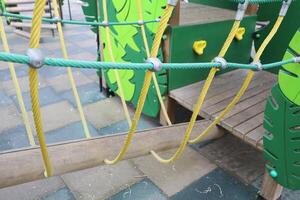 A Vibrant, Colorful Playground Climbing Structure Featuring Ropes and Leaves for Active Play photo