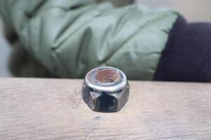 A Rusty, Worn Metal Nut Resting on an Aged Wooden Surface, Exuding Character and Charm photo
