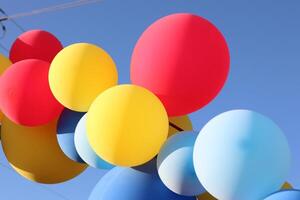 A beautiful display of colorful balloons floating against a bright and clear blue sky photo