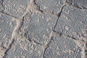 Textured Paving Stones Featuring a Grid Pattern Set Against an Urban Environment and Landscape photo