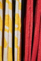 Two towels, one yellow and one red, are hanging side by side. Vertical background, wallpapers. photo