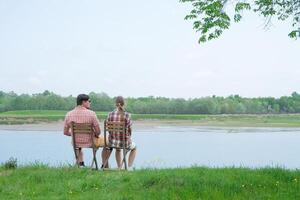 Family on picnic near the lake, looking at view back photo
