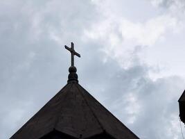 A cross is on top of a building at summer day photo