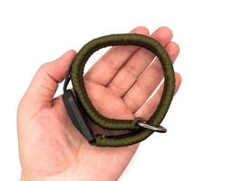 Green camera strap in the form of a rope on a white background. copy, top view, flay lay photo
