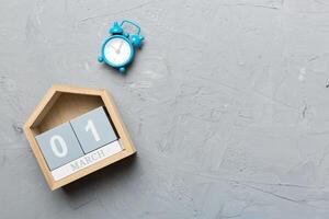 Image of March 1 wooden block calendar on colored background. Summer day. Empty space for text photo