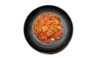 Delicious Red Fried Rice Served on a Black Plate. Isolated on White Background photo
