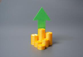 Stack of coins and green arrow pointing up. Financial growth, income increase, or investment success. Relevant for inflation trends, capital accumulation, or market optimism. photo