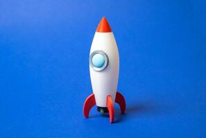 Space rocket on blue background. Concept of space aerotechnics. Advertising, startups. Advanced engineering, scientific progress, or marketing for aerospace. Tech innovation photo