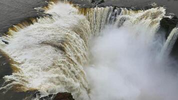 Aerial view of Iguazu Falls as countless streams plunge into misty green canyon video